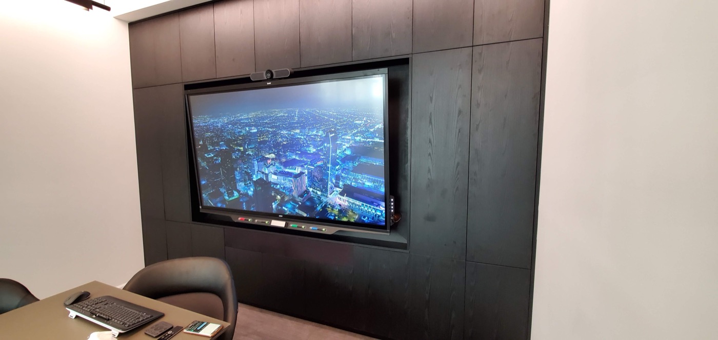 Large-format display mounted flush inside a dark wood built-in wall