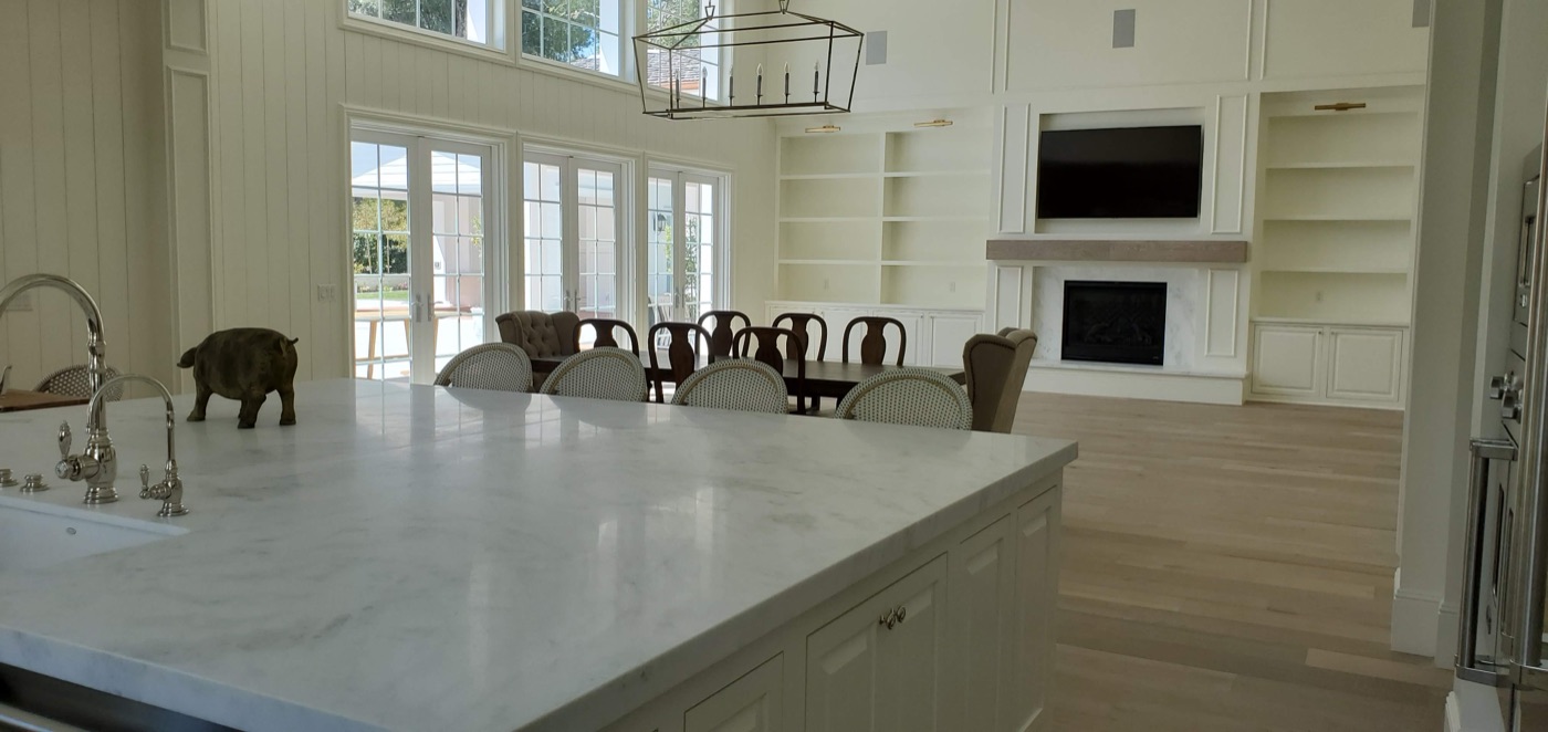 TV mounted above a marble fireplace in an upscale great room