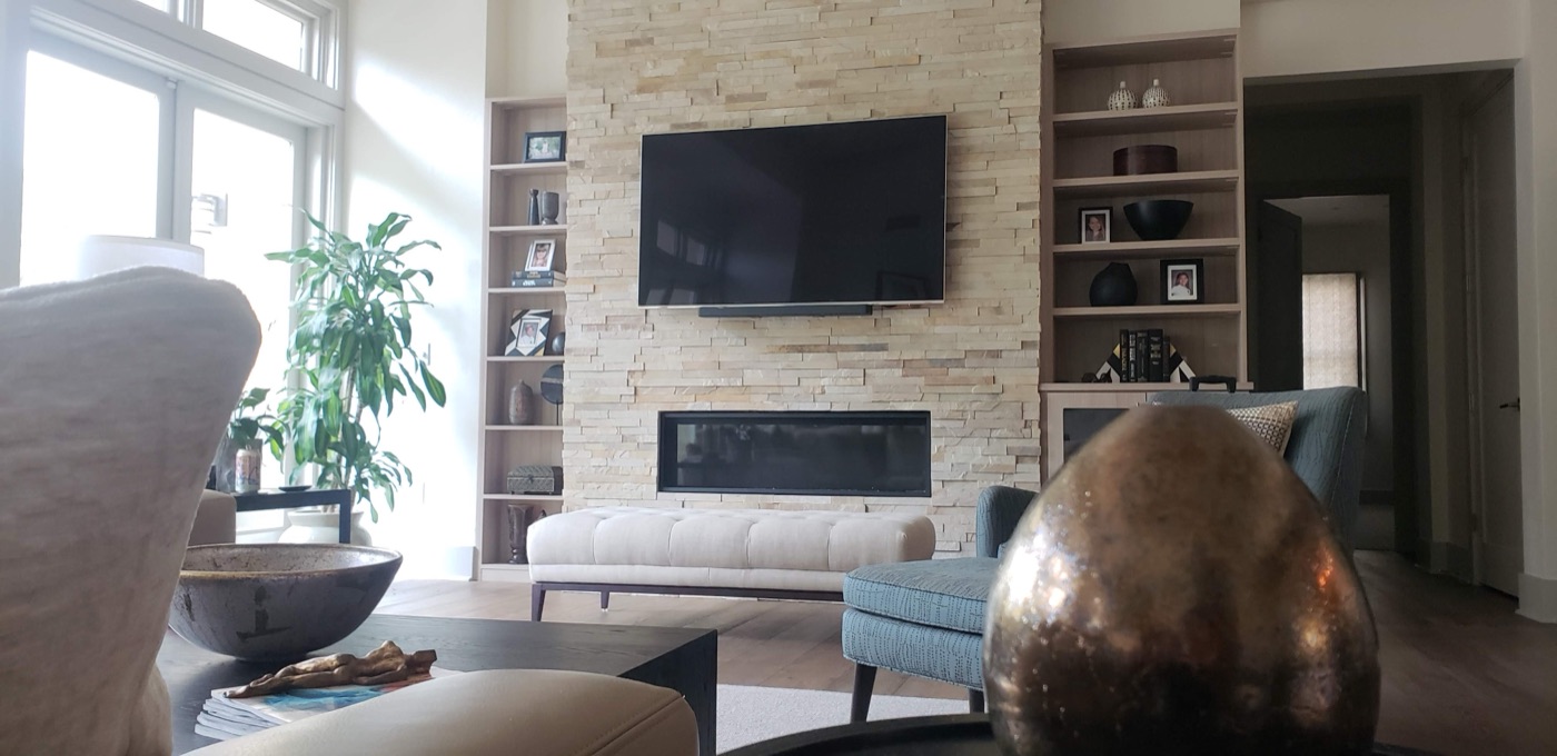 TV mounted above a linear fireplace feature wall in an upscale living room