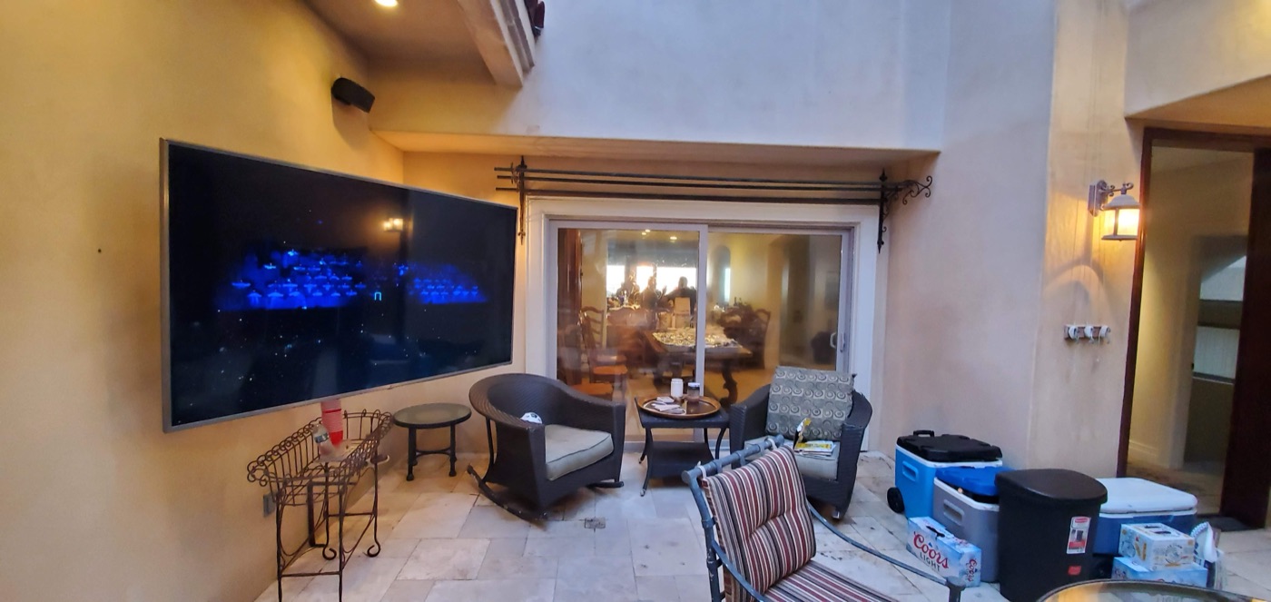 TV mounted outdoors in a stucco alcove under a covered patio