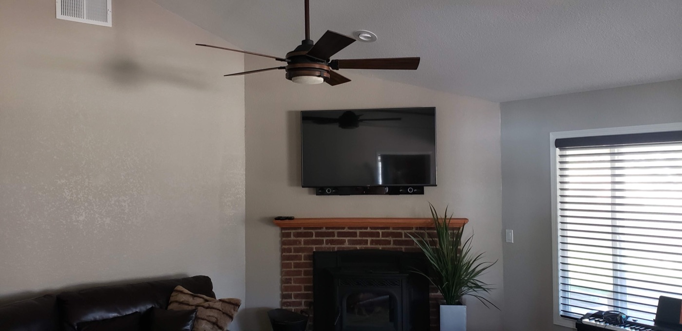 TV mounted above a stone hearth in a vaulted great room